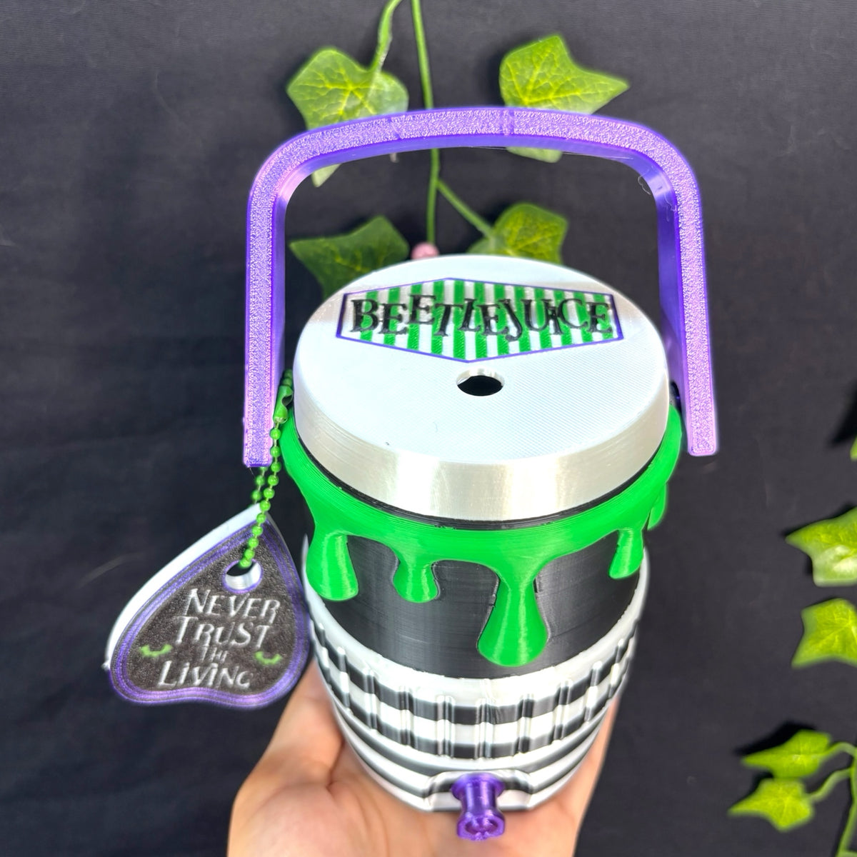 Untapped Innovations Beetlejuice themed beverage cooler with black and white stripes, neon green slime, and purple handle