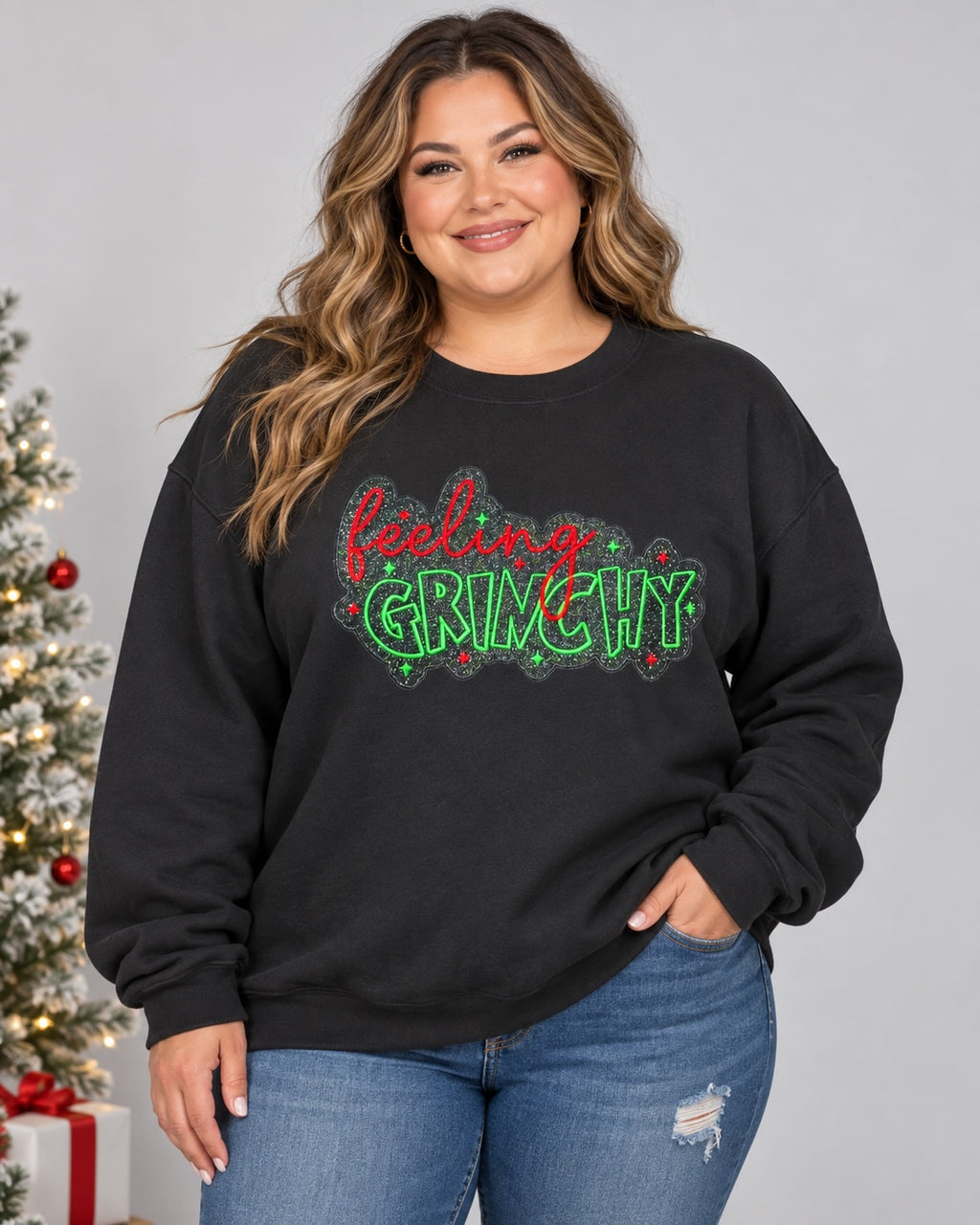 Untapped Innovations black crewneck sweatshirt with Feeling Grinchy holiday graphic in red and green glitter lettering.