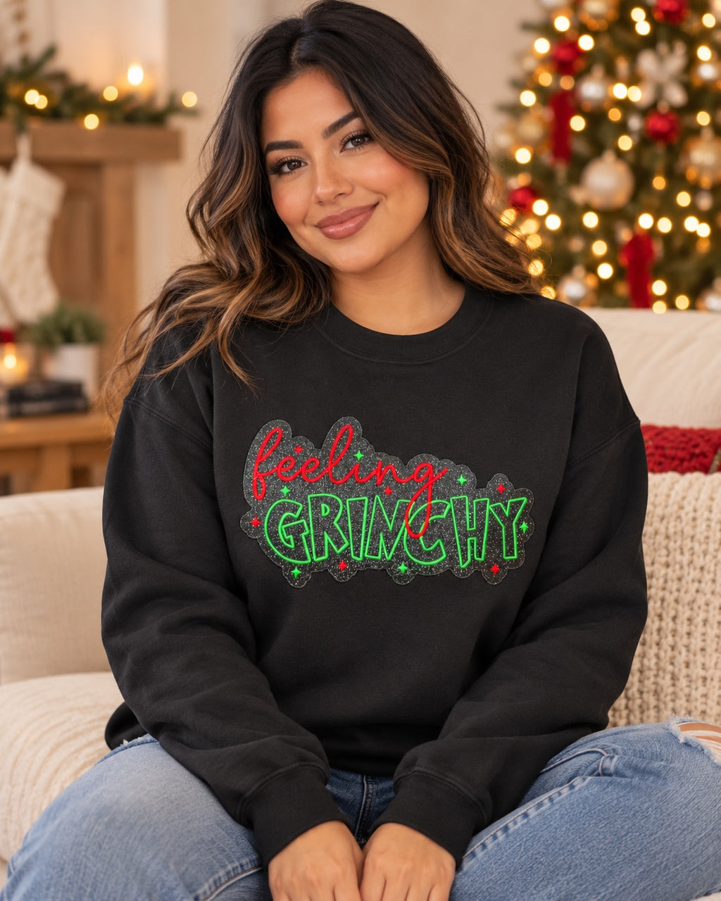 Woman wearing an Untapped Innovations black crewneck sweatshirt with a festive Feeling Grinchy glitter graphic