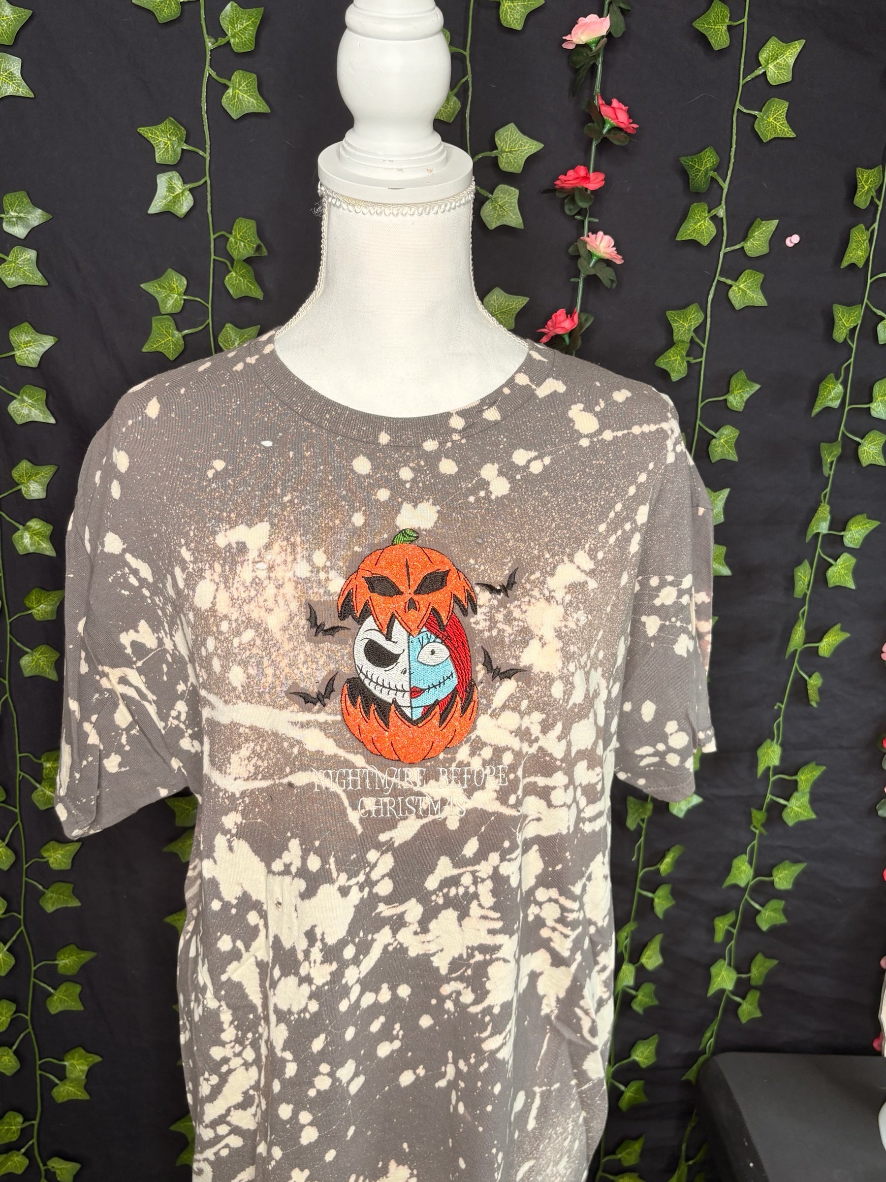 Untapped Innovations bleached t-shirt featuring embroidered Jack and Sally in a pumpkin with bats on a mannequin.