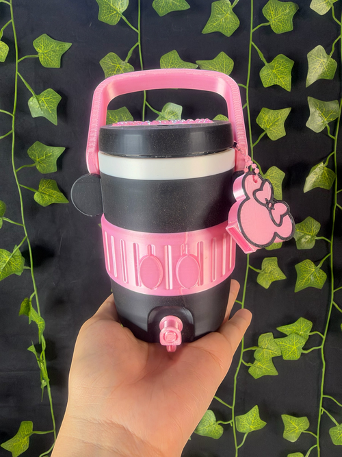 Untapped Innovations character-inspired portable beverage dispenser in black and pink with a spigot and handle.