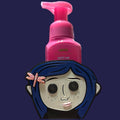 Untapped Innovations Coraline foaming hand soap holder with blue hair, button eyes, and a pink dragonfly hair clip.