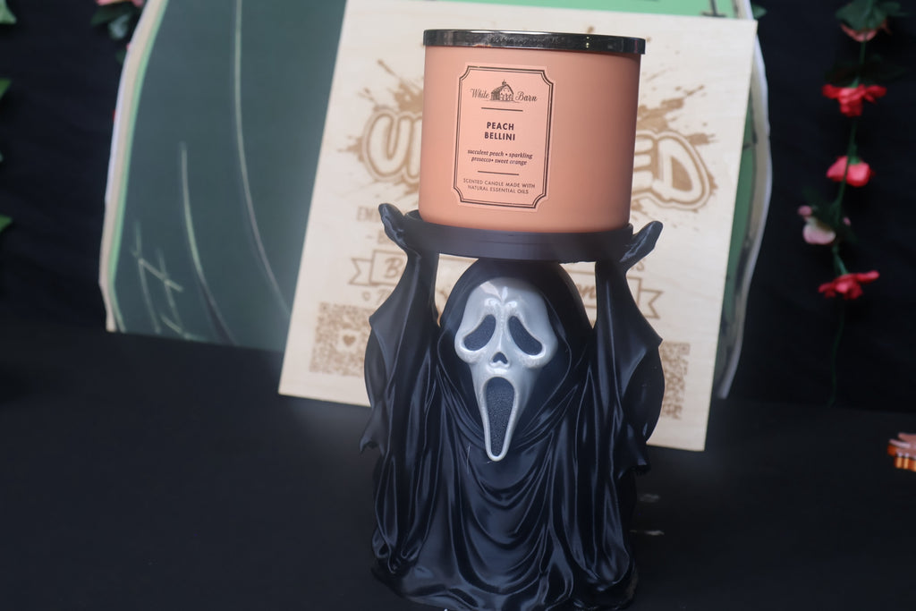 Untapped Innovations horror-themed ghost figure candle holder supporting a peach-scented three-wick candle