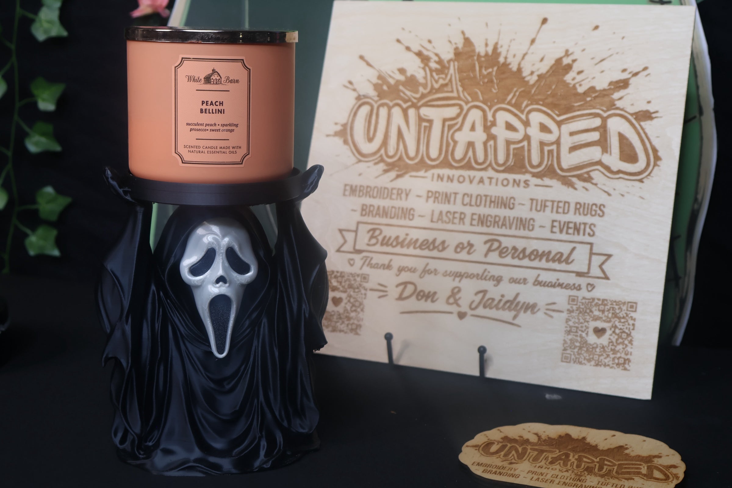 Untapped Innovations horror-themed ghost figure candle holder stand holding a peach scented three-wick candle.