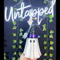 Untapped Innovations 3D-printed white ghost figurine wearing a black witch hat with a purple band and BOO charm.