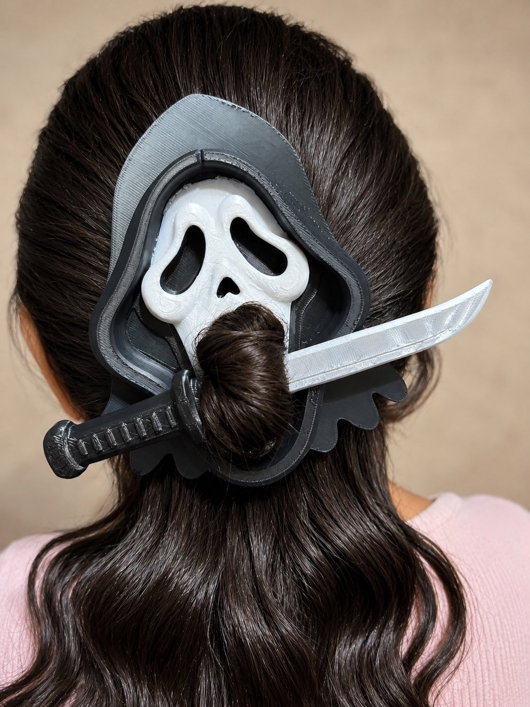 Untapped Innovations horror movie ghost mask hair bun holder with a silver blade design on dark wavy hair