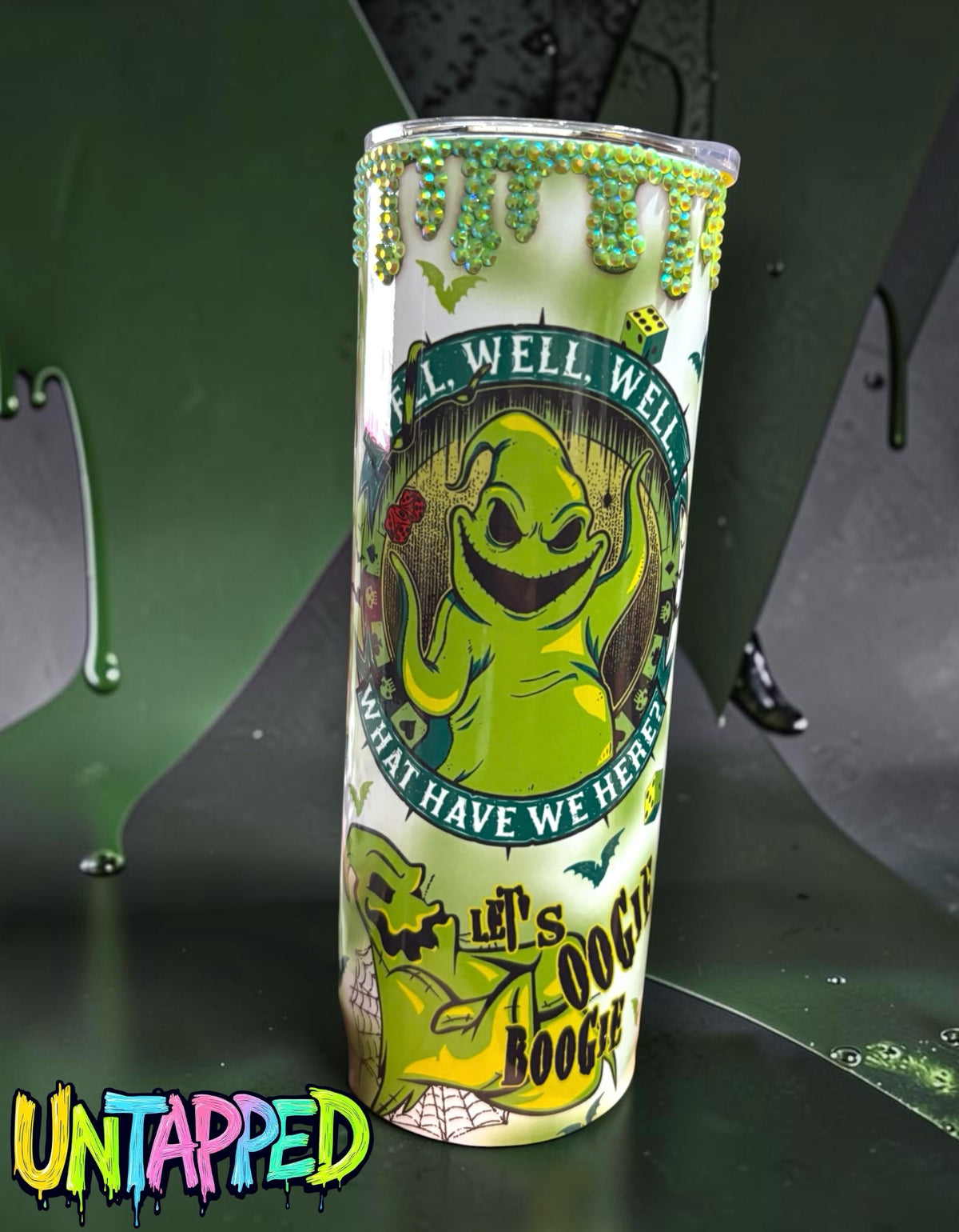 Untapped Innovations Oogie Boogie themed stainless steel tumbler with green character art and rhinestone drip rim.