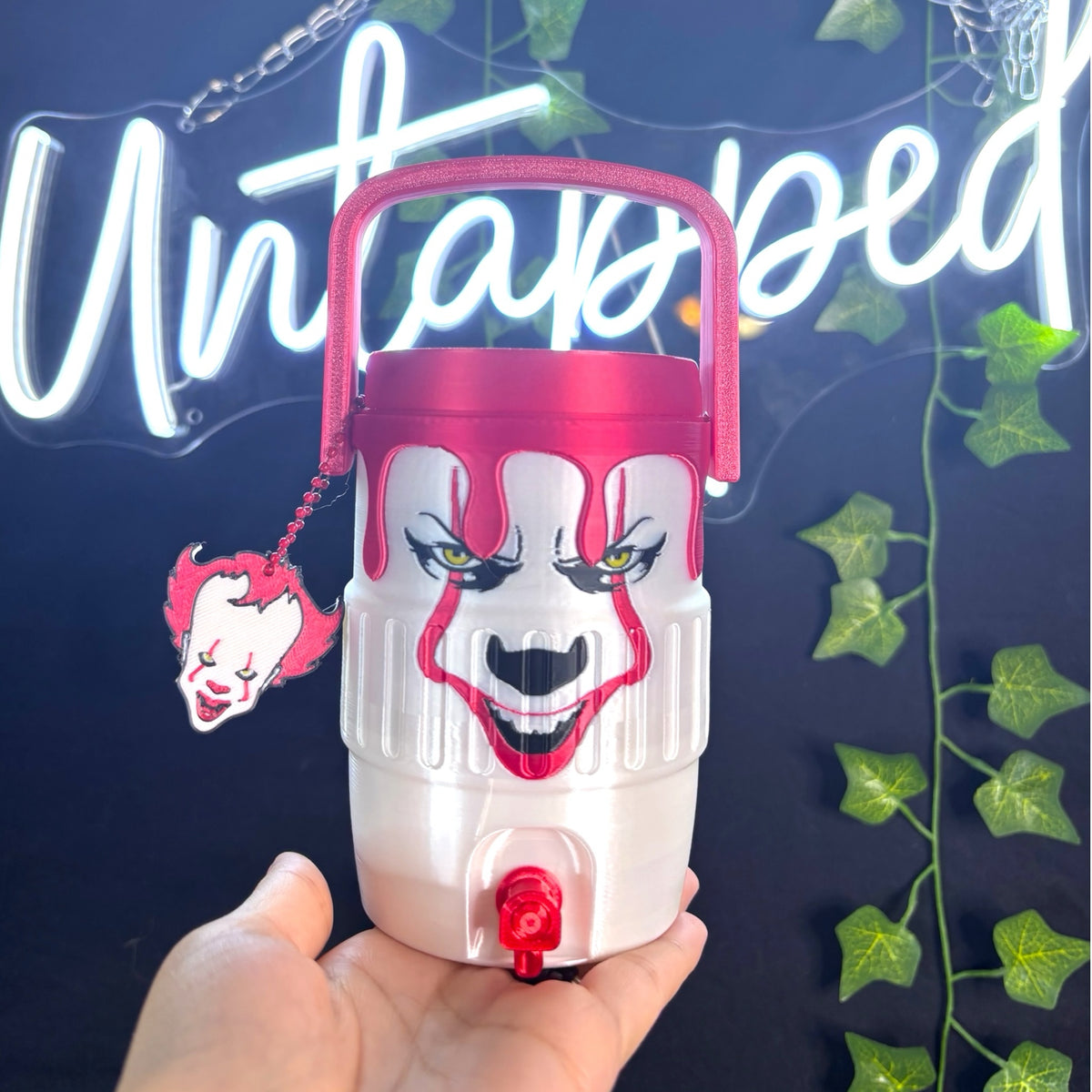 Untapped Innovations Pennywise horror themed beverage dispenser with dripping red lid, spigot, and clown charm.