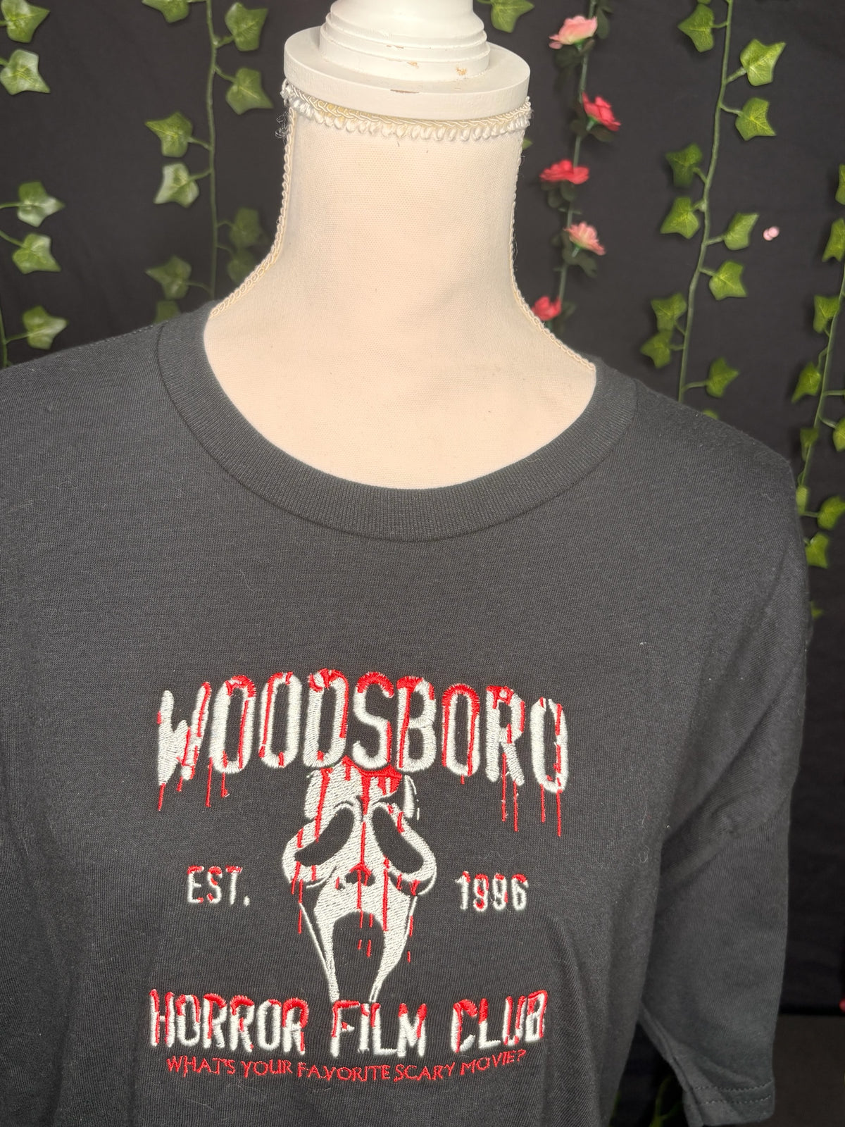 Untapped Innovations black crewneck t-shirt with embroidered Woodsboro Horror Film Club design and iconic mask graphic.