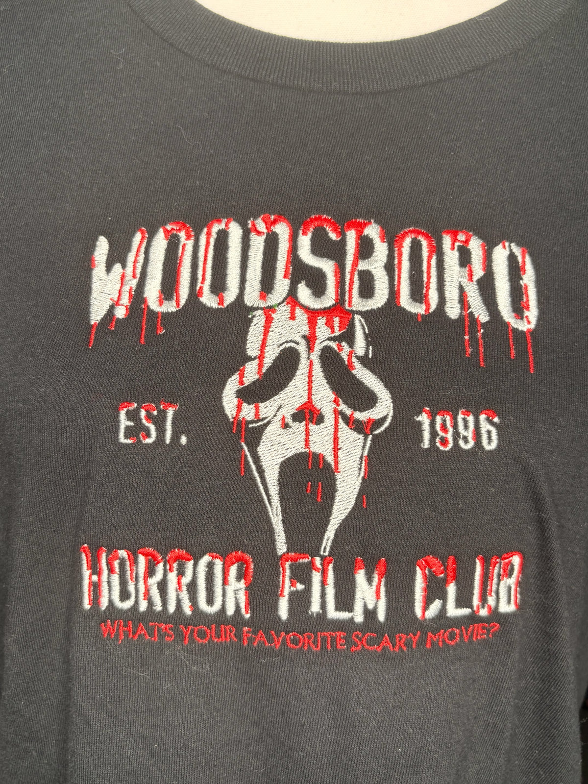 Untapped Innovations black graphic t-shirt featuring embroidered Woodsboro Horror Film Club mask and bloody text
